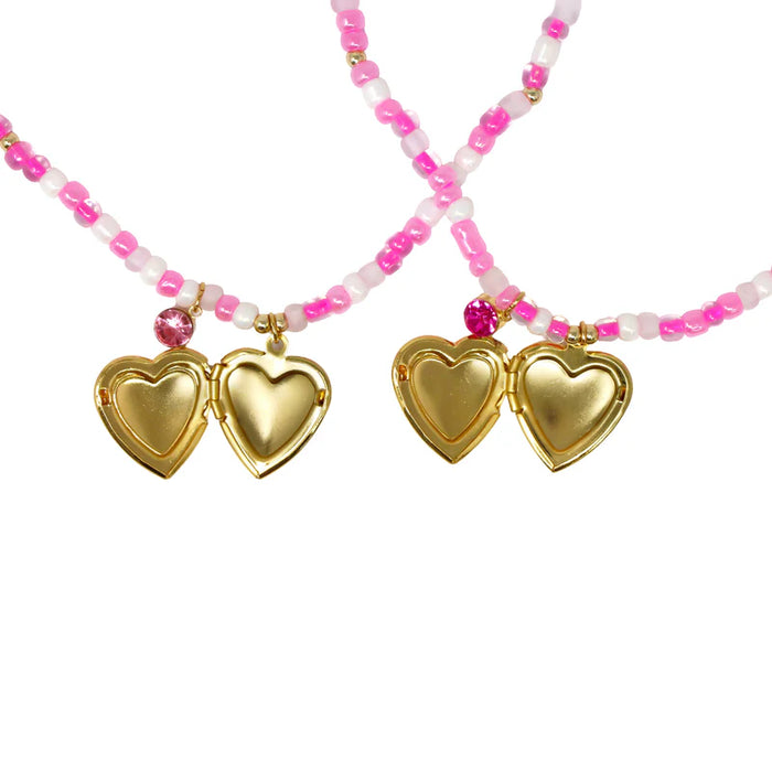 Necklace with gold heart pendants and pink and white bead chain on a white background